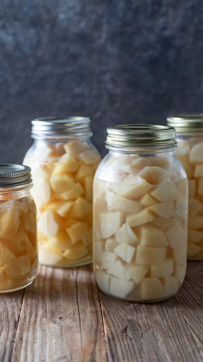 Diced potatoes in jars with barn wood board.