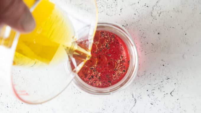 Pouring oil into jar.