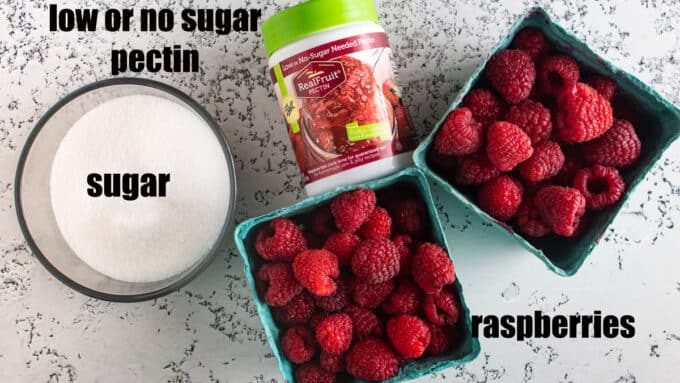 Raspberries, sugar and pectin on white board.