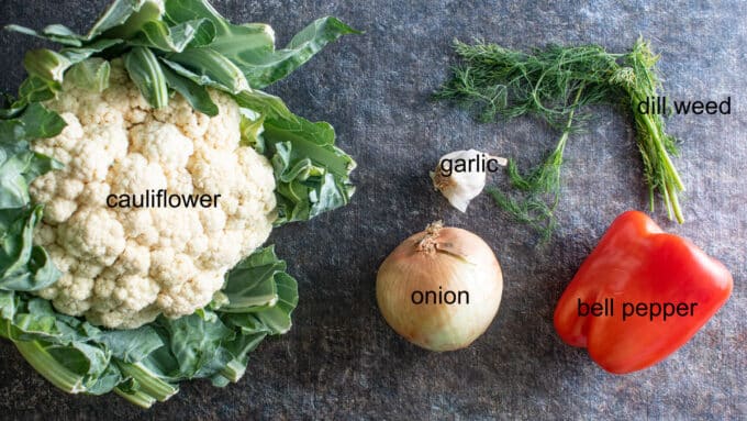cauliflower, onion, garlic, red pepper, dill on dark board