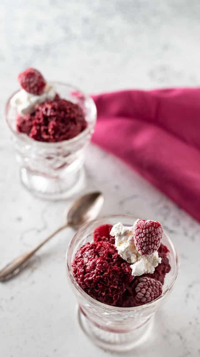 Close up of raspberry sherbet in crystal footed dessert dish.