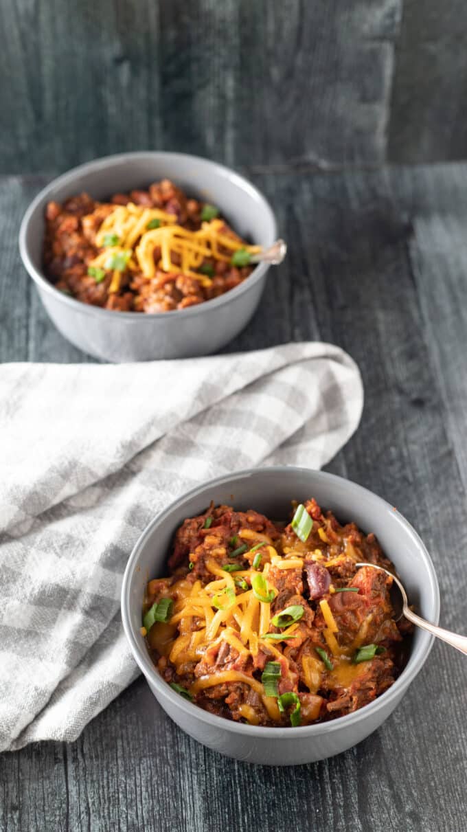 Two bowls of chili in gray bowls.