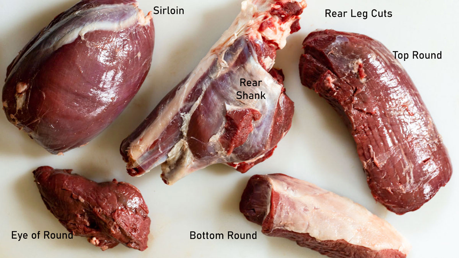 Venison cuts on a white board.