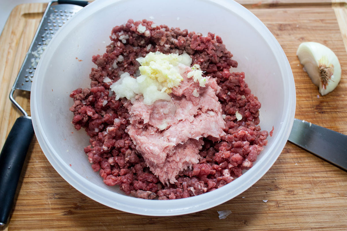 Onion and garlic grated into the bowl with the meat.