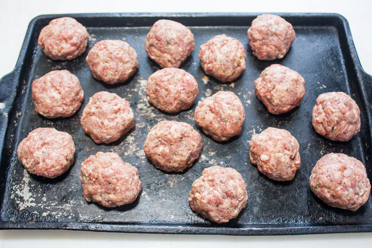 Formed meatballs on a baking sheet.