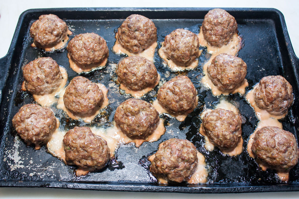 Cooked meatballs on the baking sheet.