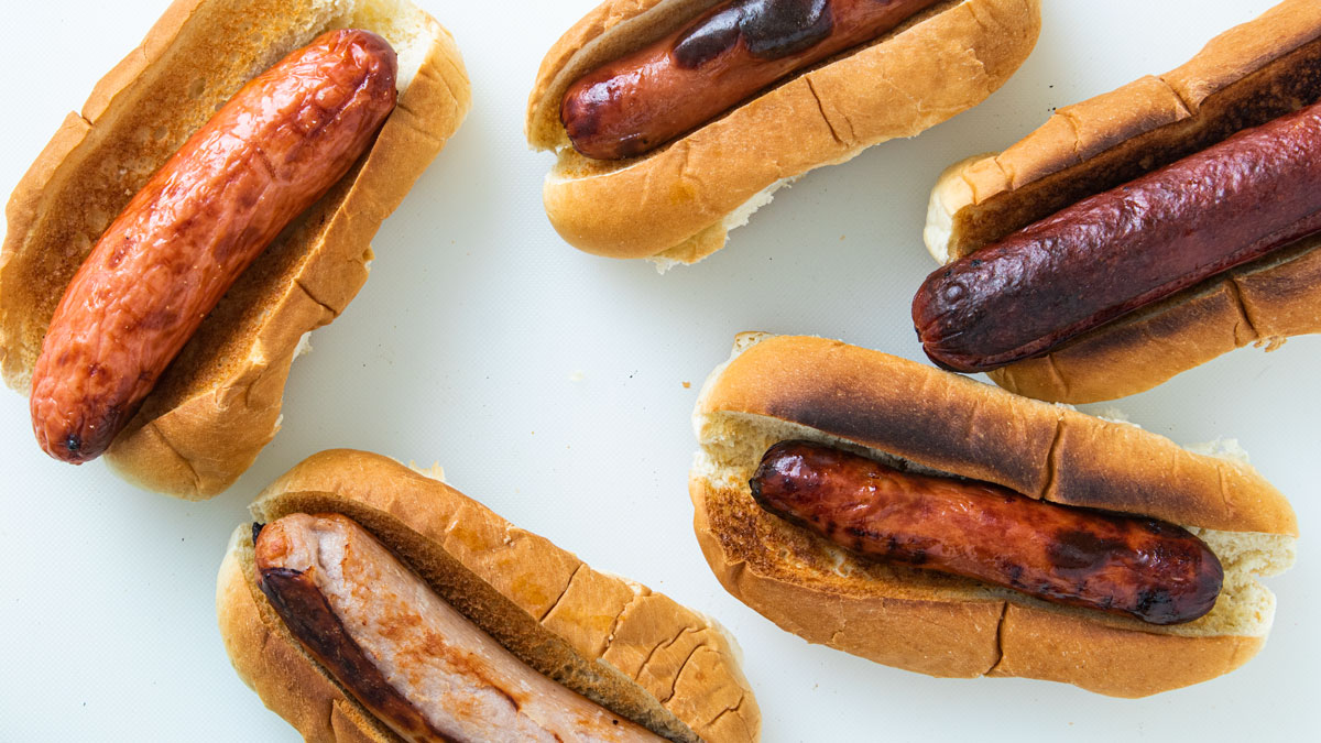 Five assorted hot dogs on rolls.