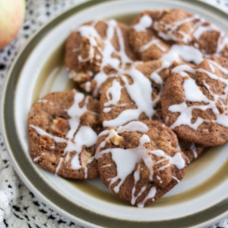 Plate full of apple cookies drizzled with powdered sugar glaze.