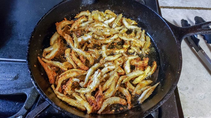 Browned smelt in cast iron pan with oil.