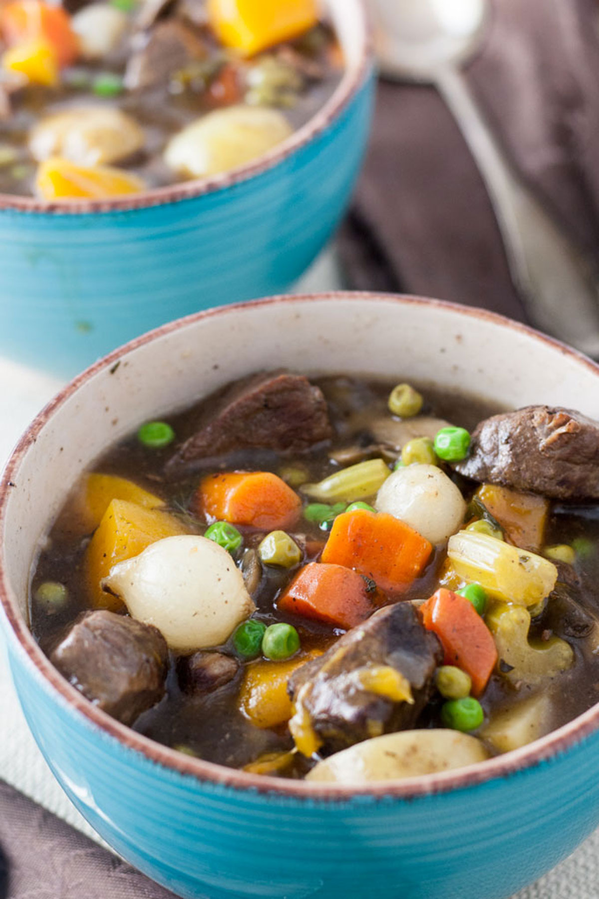 Close up of venison stew in blue bowl.
