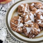 Glazed apple cookies piled on plate.