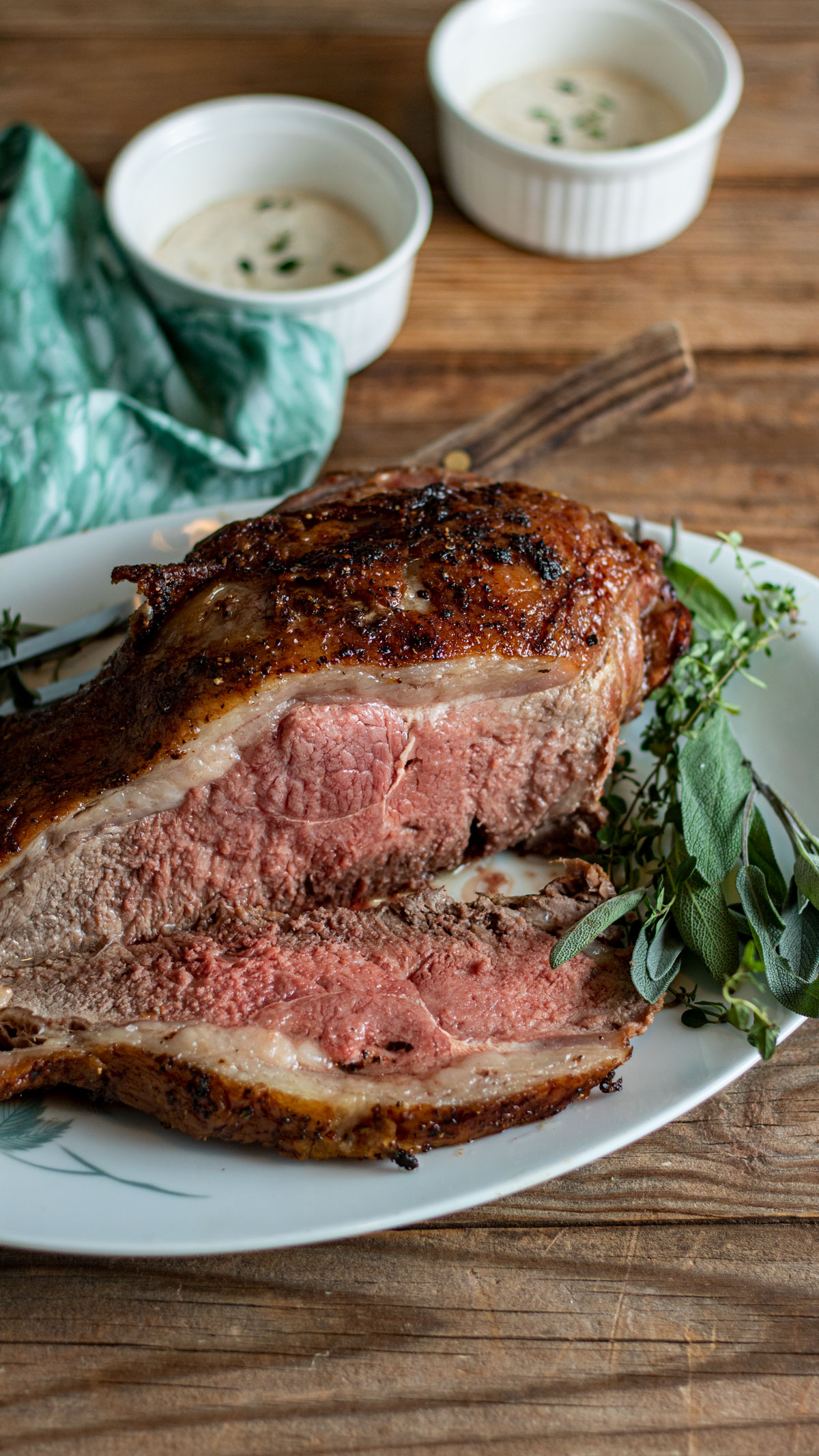 Sliced whole roast with herbs as garnish.
