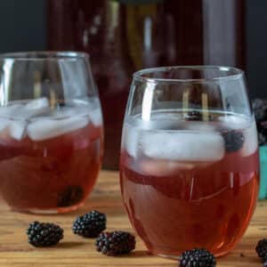 Blackberry tea in glasses garnished with blackberries.