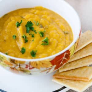 Butternut squash soup in bowl with fall leaves.