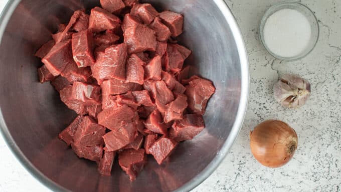 Ingredients for canning venison. Meat, salt, onion, garlic.