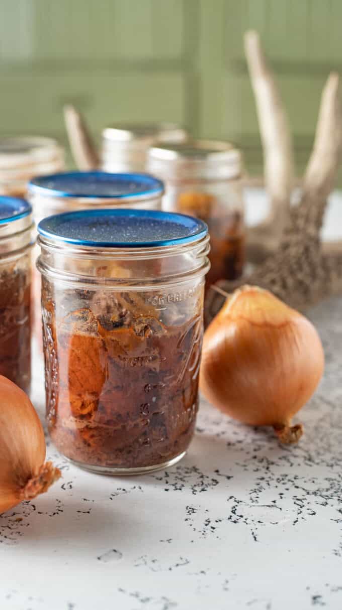 Canned venison in jars with blue lid.