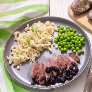 Slices of duck breast with blueberry sauce.