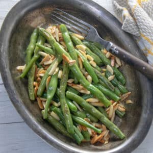 Green beans with almonds in antique pewter bowl.