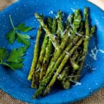 Grilled asparagus on blue pewter plate.