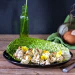 Chicken salad in a romaine lettuce leaf garnished with edible violets.