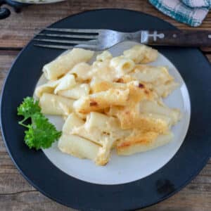 Macaroni and cheese on white plate with black rim.