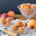 Peach sorbet garnished with peach slice on various height glass bowls.