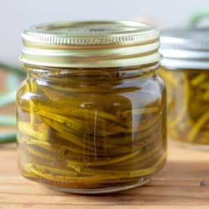 Pickled garlic scapes in a canning jar.