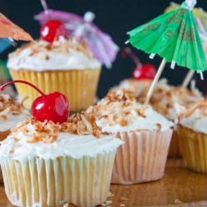 White pina colada cupcakes with cherry on top.