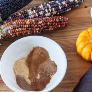 White bowl filled with spices for pumpkin pie spice.