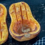 Half of a roasted butternut squash on antique tray.
