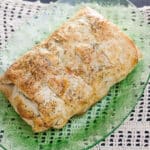 Salmon wrapped in pastry on green platter.