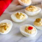 Deviled eggs topped with candied jalapenos.