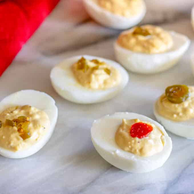 Deviled eggs topped with candied jalapenos.