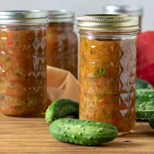 Sweet pickle relish in jars with cucumbers.