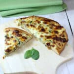Slices of tuna pizza on wooden pizza peel.