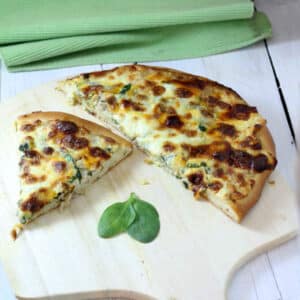 Slices of tuna pizza on wooden pizza peel.