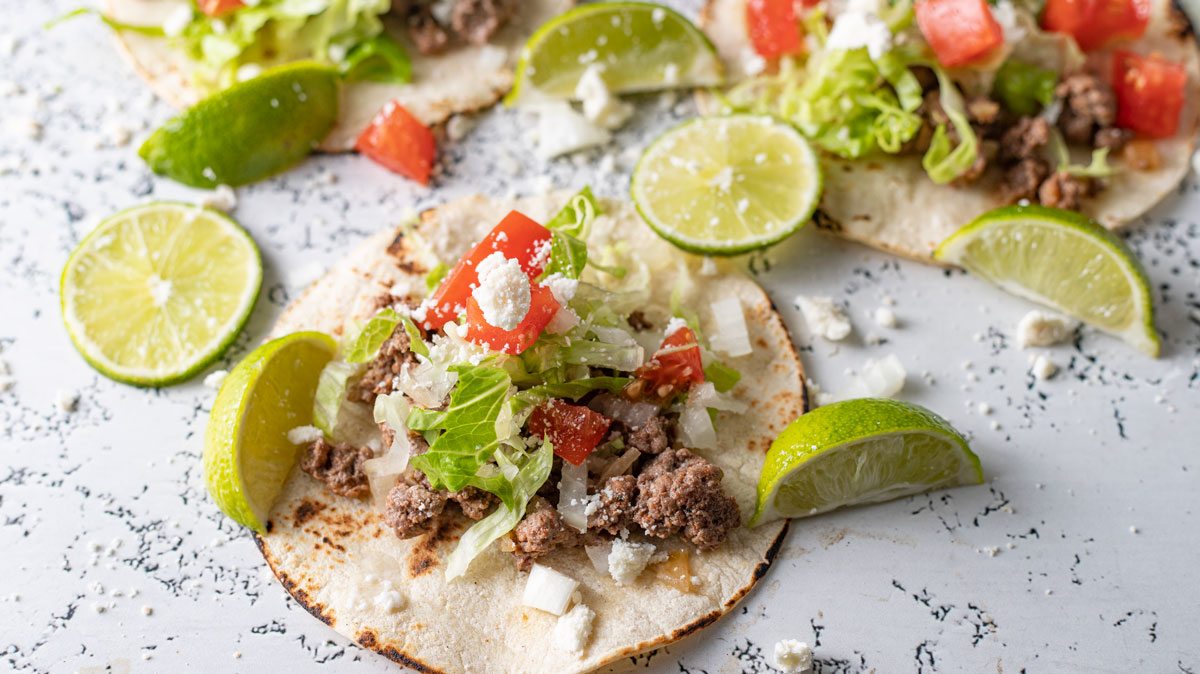 Venison chorizo tacos with colorful garnish.