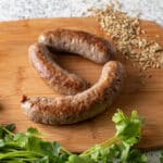 3 Italian sausage on wooden cutting board.