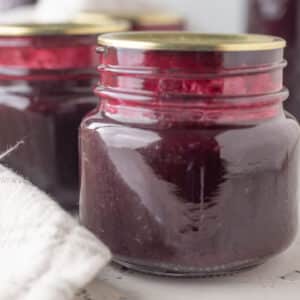 Close up of jars of blueberry syrup.
