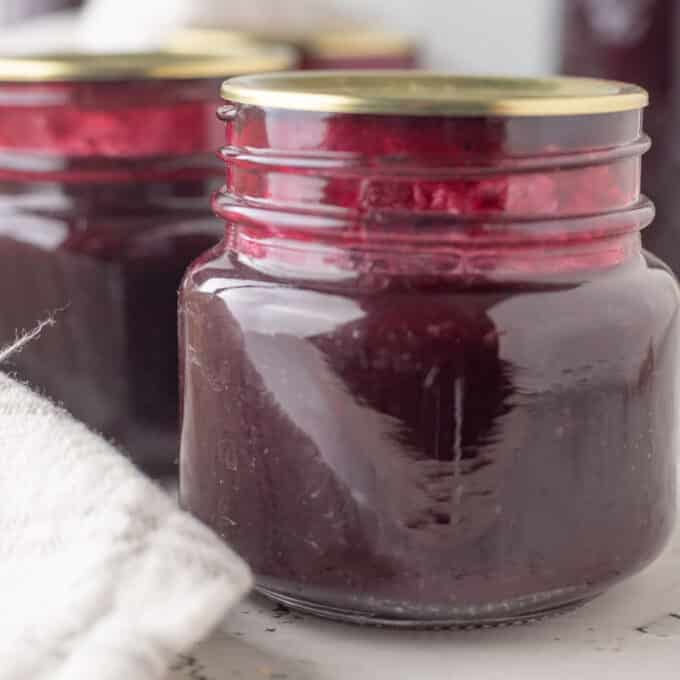 Close up of jars of blueberry syrup.