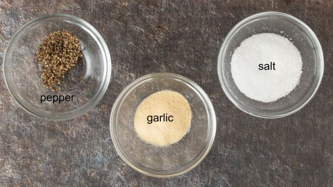 Salt, pepper and garlic in small bowls.