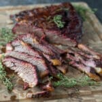 Sliced beef brisket on wooden cutting board.