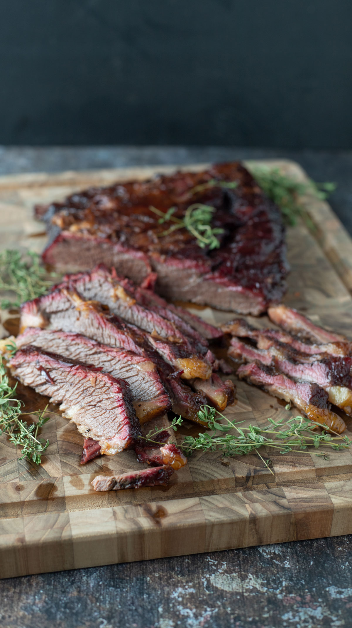 Sliced beef brisket on wooden cutting board.