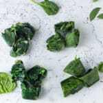 4 types of frozen spinach on white board.