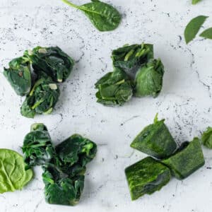 4 types of frozen spinach on white board.