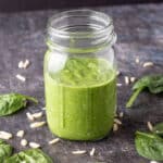 Jar of pesto on black board.