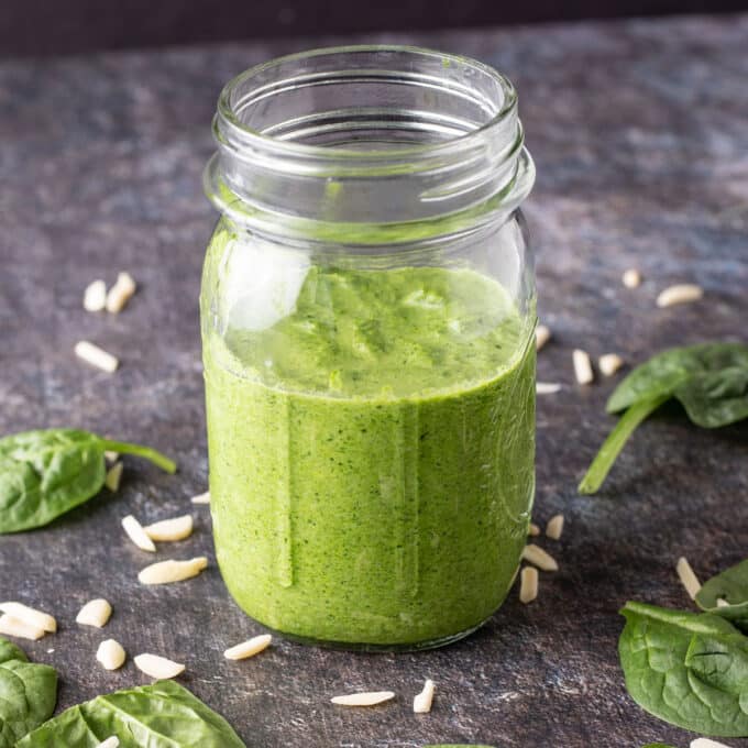Jar of pesto on black board.