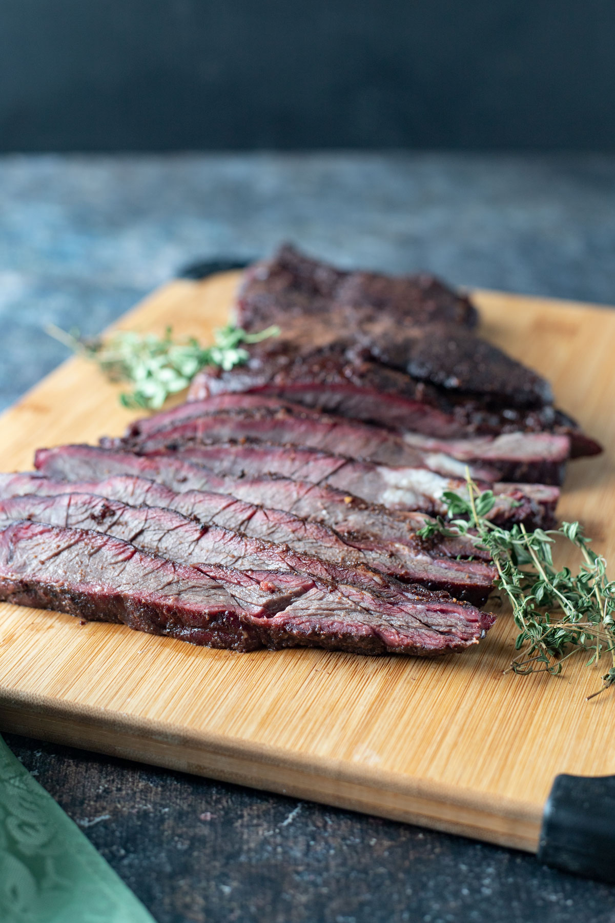 Sliced deer brisket on wooden cutting board.