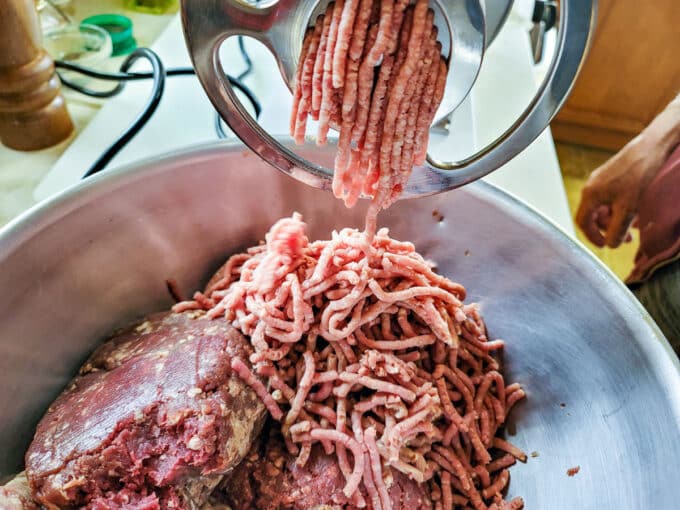 Grinding meat into a bowl.