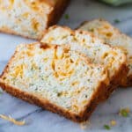 Sliced zucchini cheese bread on marble board.